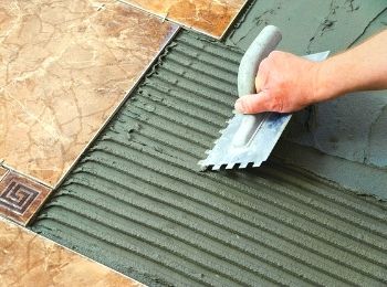 Нанесение раствора для поклейки плитки на пол